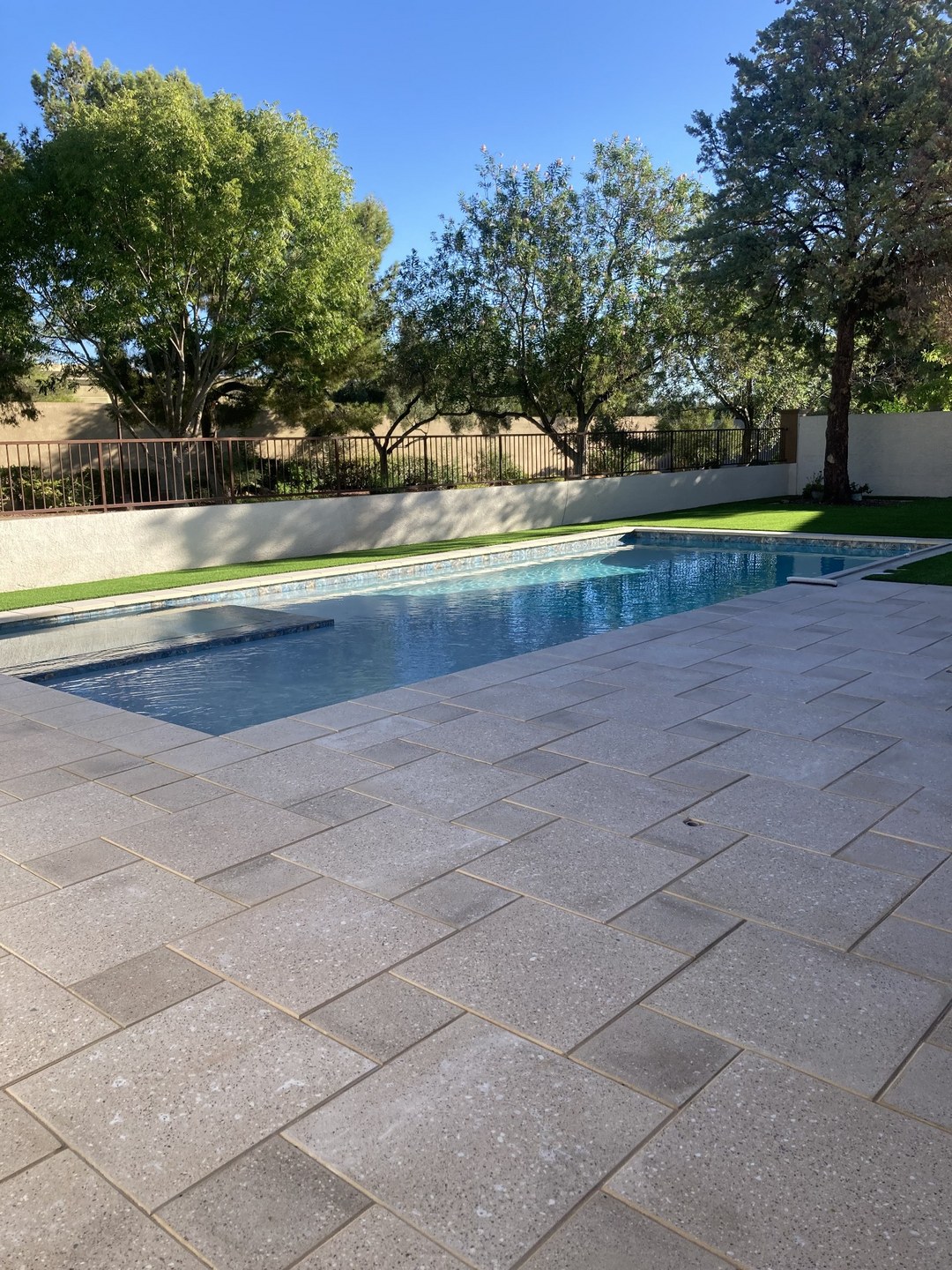 Backyard after MSWT remodel — new pool, paver deck and turf