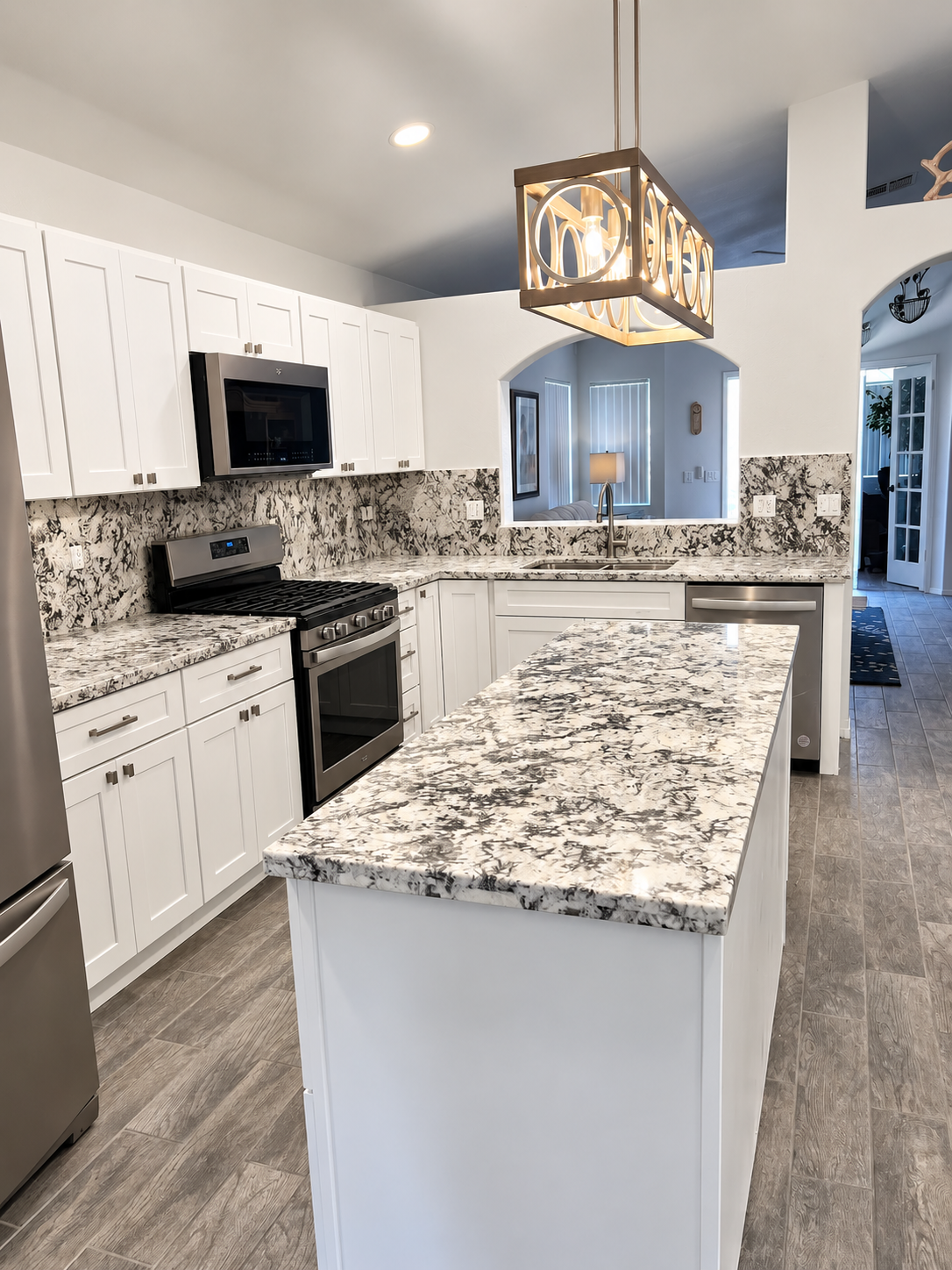 Completed MSWT kitchen remodel with white shaker cabinetry, granite countertops and island