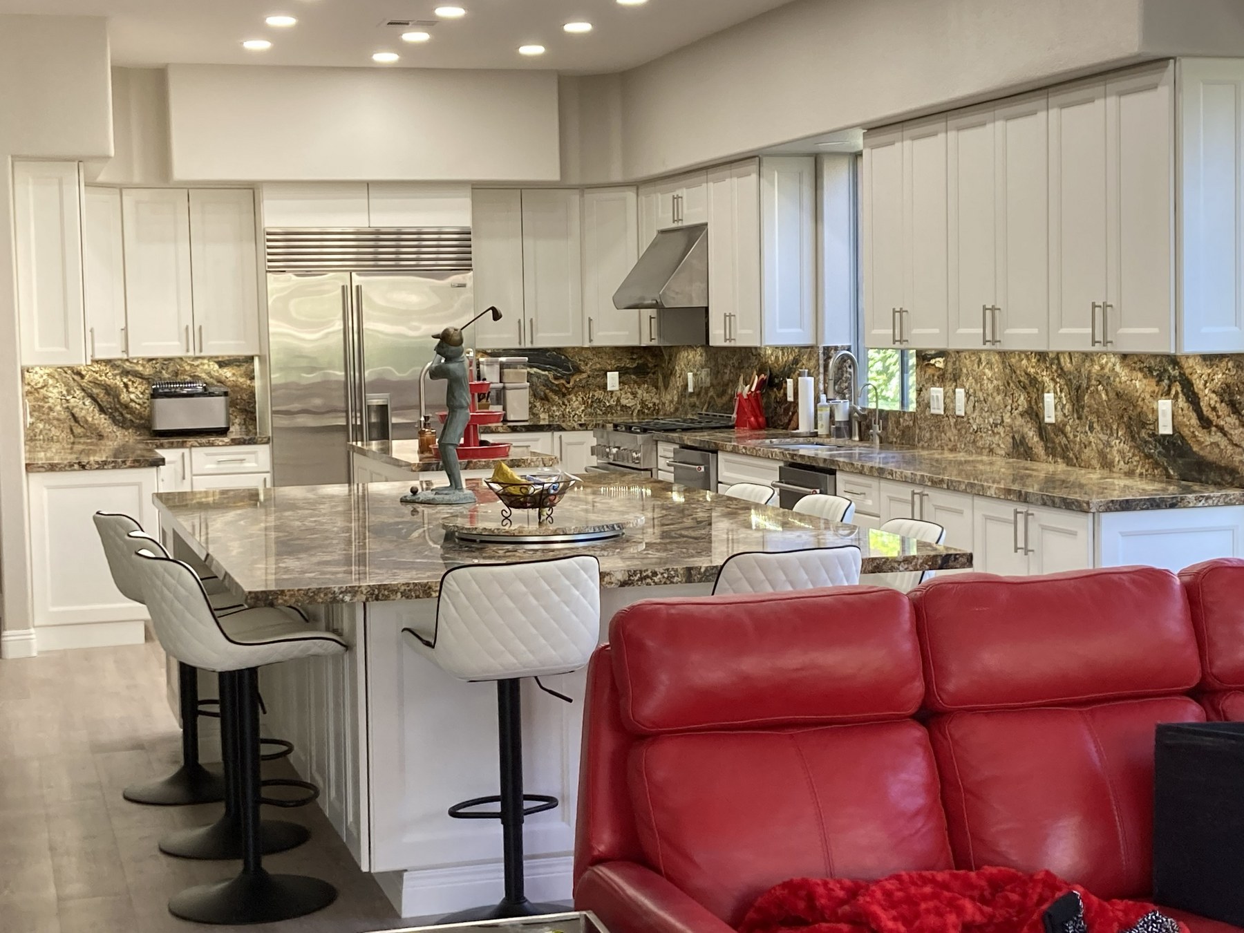 Kitchen after MSWT remodel — white cabinetry, granite island and countertops